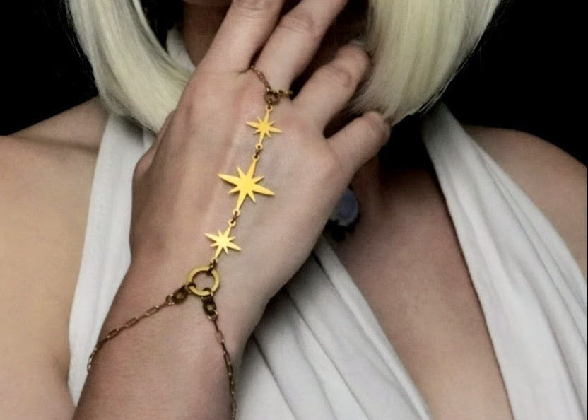 Person wearing a star-shaped bracelet on a black background