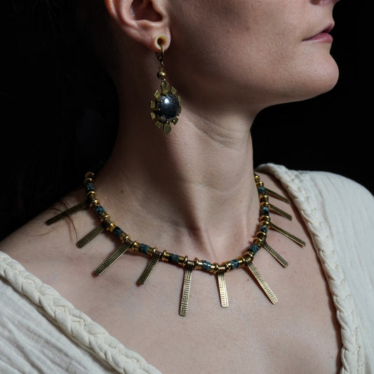 Woman wearing a necklace and earrings against a dark background